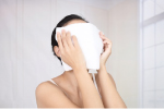 蒸しタオルを顔に押し当てる女性